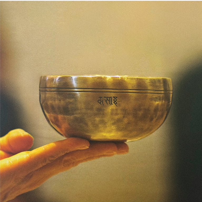 Hand holding a brass singing bowl