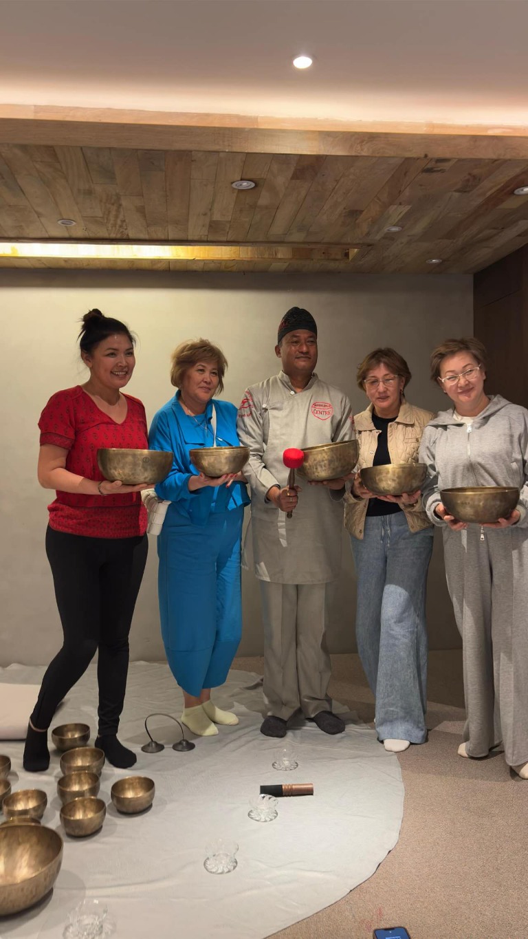 Master Saroj with workshop participants holding singing bowls