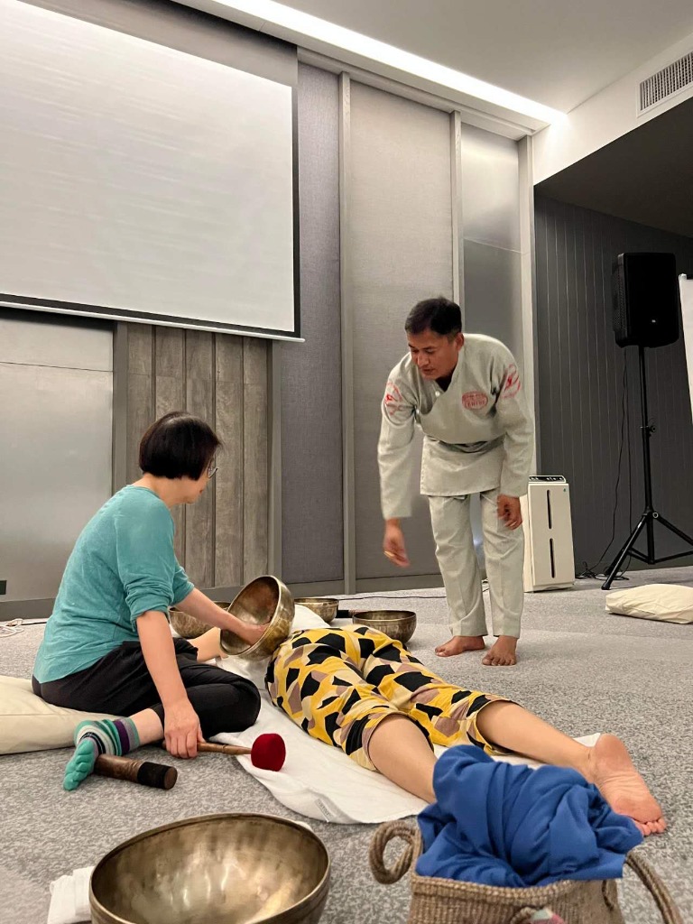 A guest participating in a singing bowl practice session